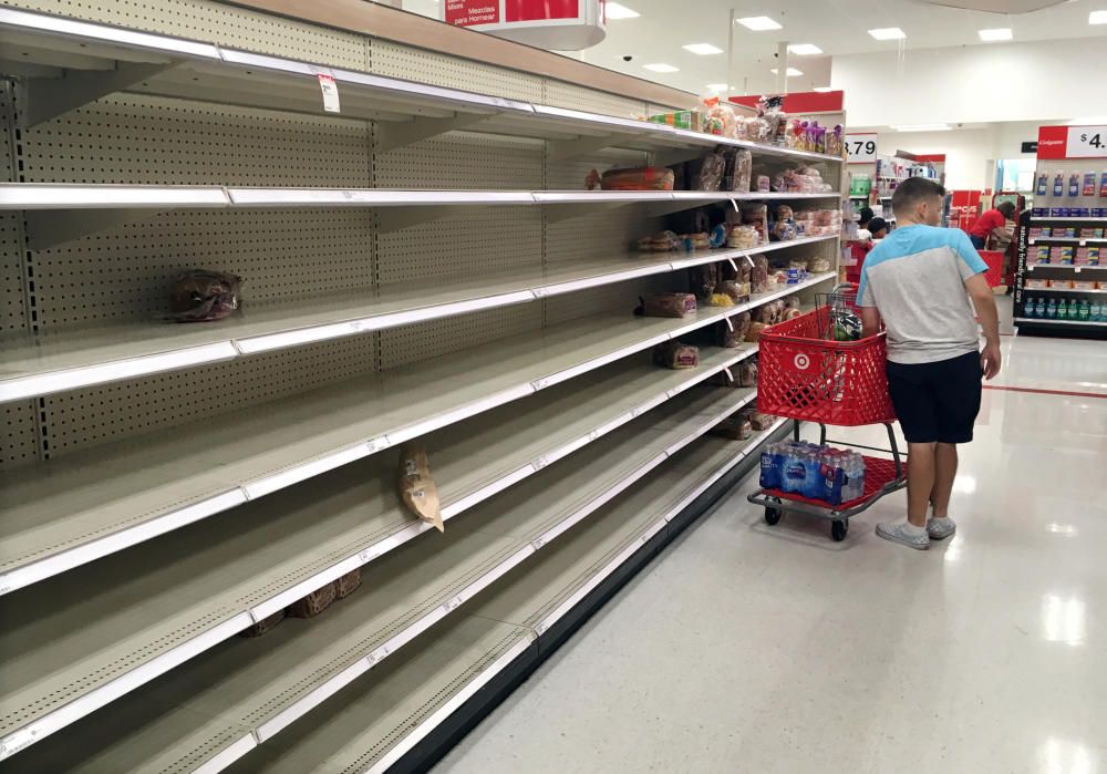 Shoppers find empty bread shelves at a store ...