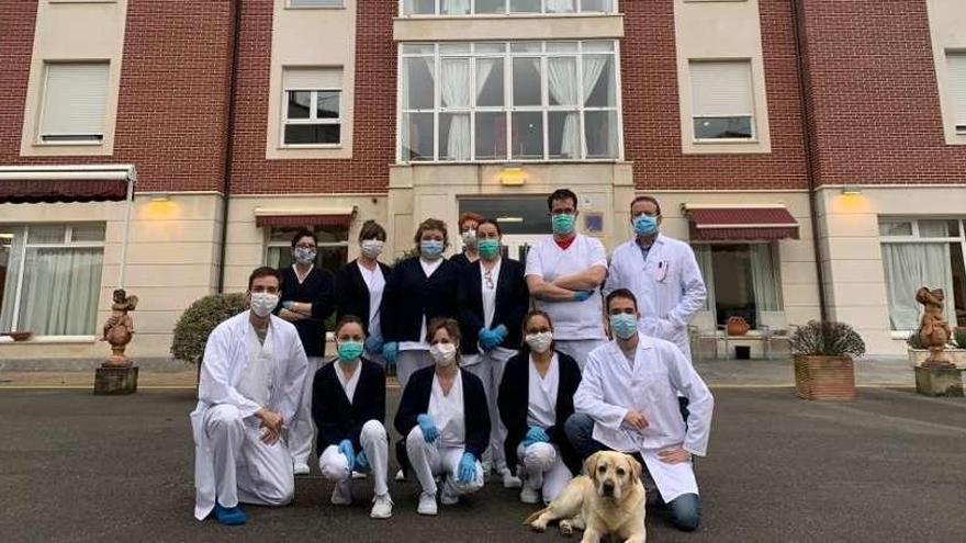 Trabajadores confinados en la residencia de Nava con la mascota del centro, el perro &quot;Leo&quot;.