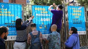 Pancartas de la campaña ’¿Votas aquí? Matrícula a tus hijos e hijas aquí’ en el colegio Collaso i Gil, en el barrio del Raval, en Barcelona. 