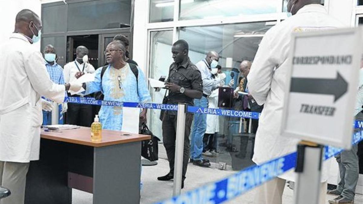 Sanitarios inspeccionan a viajeros procedentes de Guinea, en el aeropuerto de Abidjan, en Costa de Marfil.
