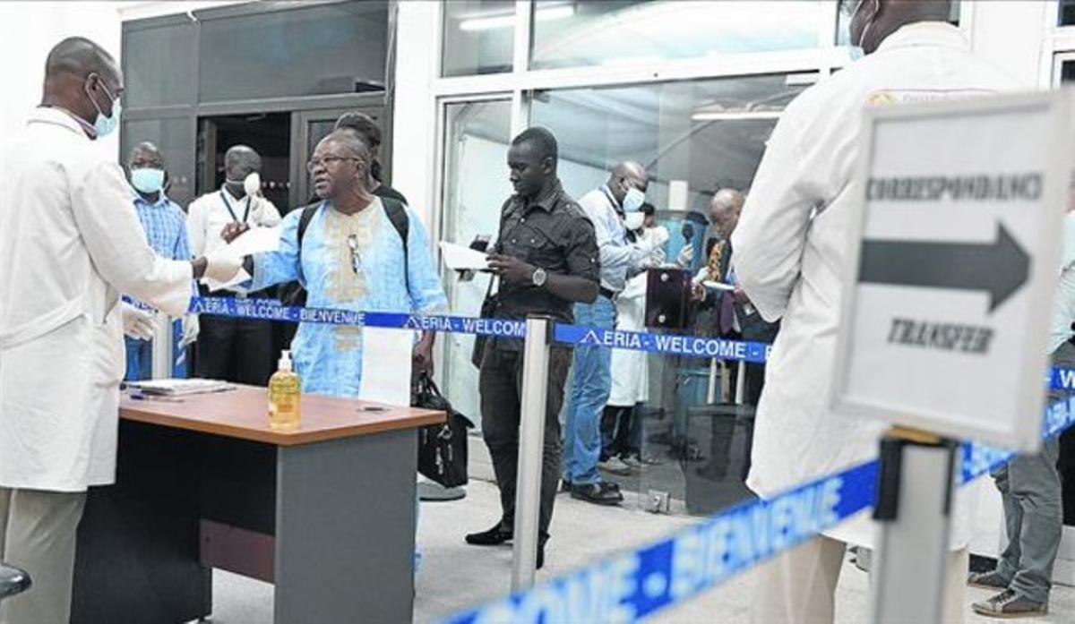 Sanitaris inspeccionen viatgers procedents de Guinea, a l’aeroport d’Abidjan, a Costa d’Ivori.