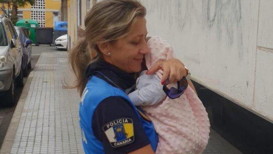 Una agente de Las Palmas de Gran Canaria cuida a un bebé mientras sus compañeros intermedian en una riña familiar