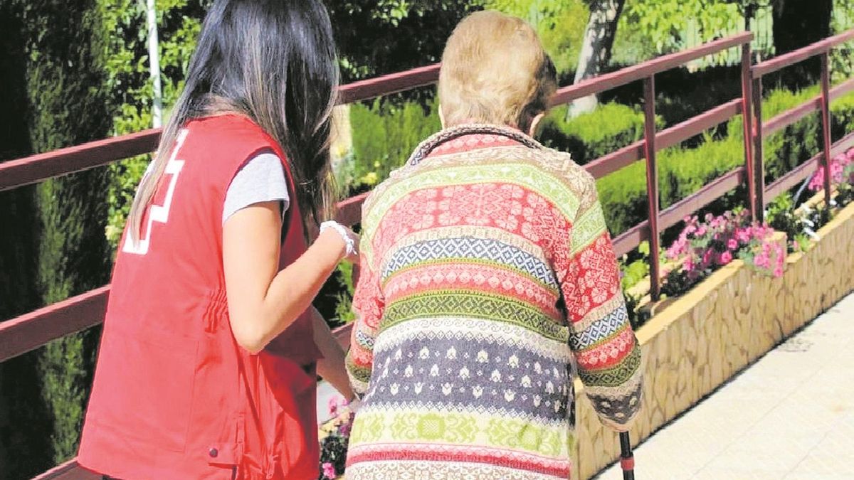 Una treballadora de la Creu Roja atén una dona gran en una imatge d'arxiu.