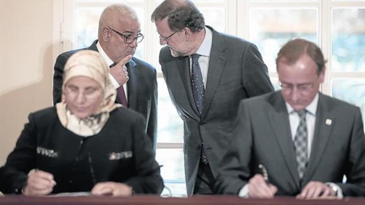 Los presidentes de Marruecos, Abdelilá Benkirán, y España, Mariano Rajoy, conversan, ayer, mientras los ministros de Sanidad firman un acuerdo.