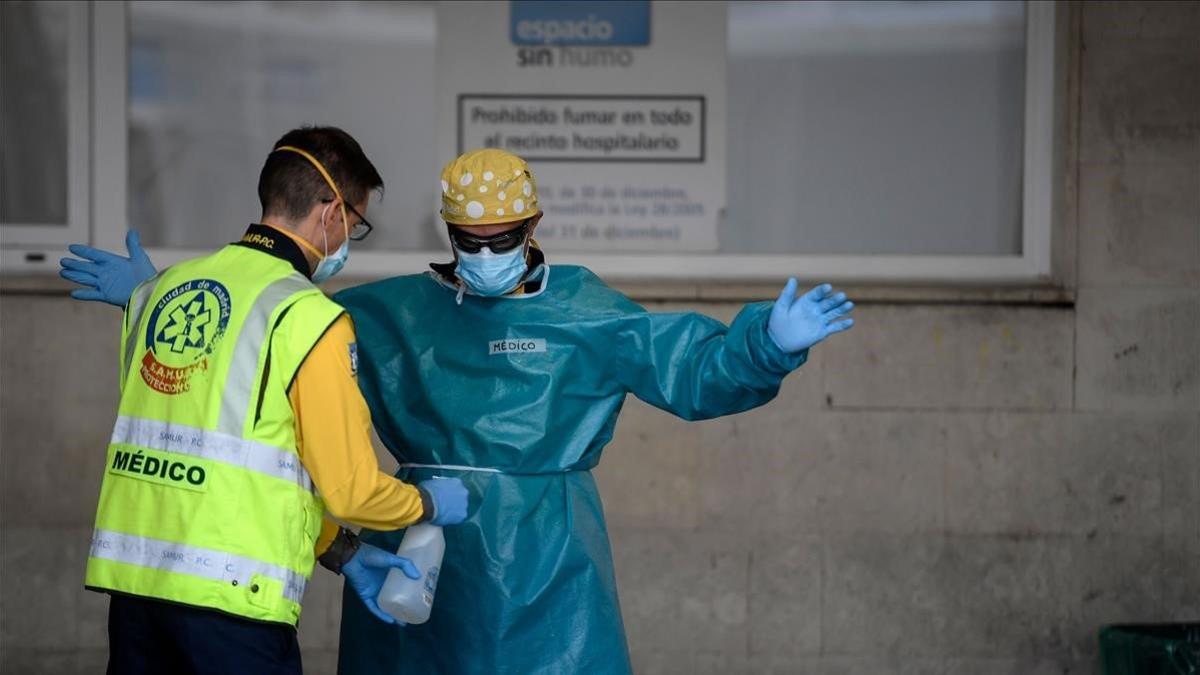 Sanitarios desinfectan sus equipos protectores tras transportar a un paciente en una ambulancia al Hospital Doce de Octubre de Madrid, el 28 de octubre del 2020