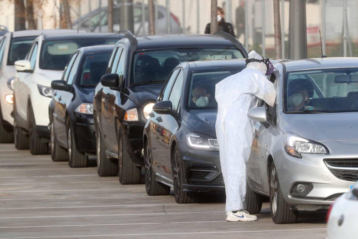 Un sanitario realiza pruebas PCR en coches en València.