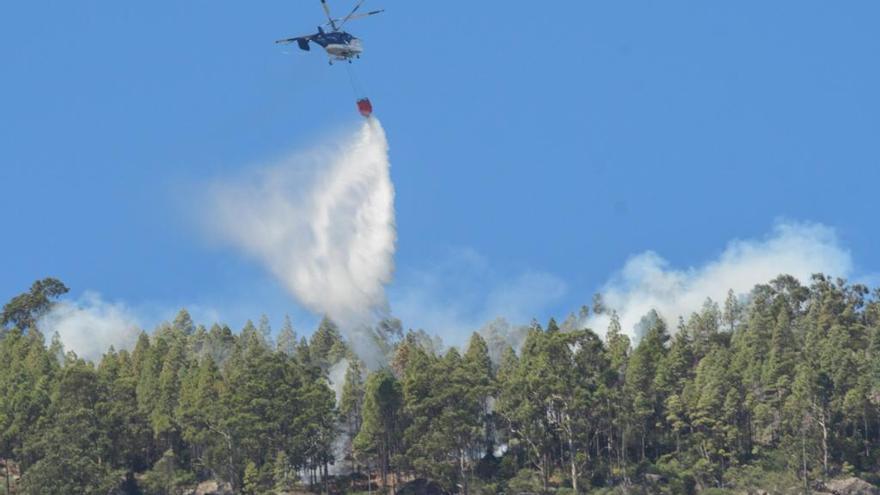 Un helicóptero echa agua para apagar el incendio de Agaete.