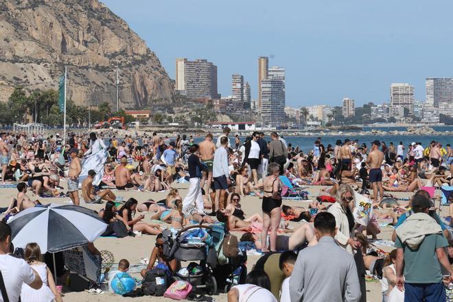 El buen tiempo de este Jueves Santo llena la playa del Postiguet de Alicante