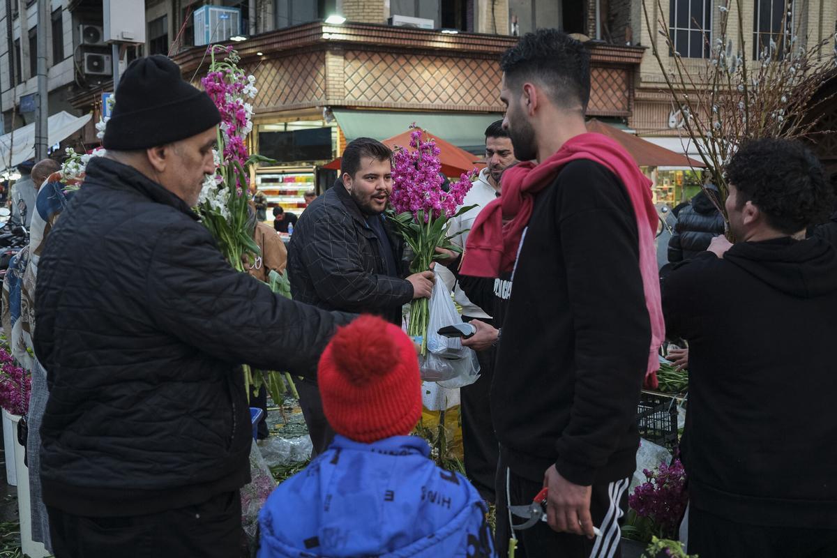 Un hombre compra flores en el bazar de Tajrish en el norte de Teherán en el día Noruz.