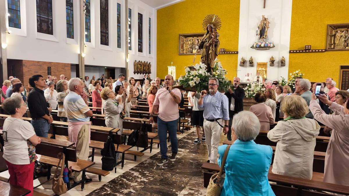 La procesión de la imagen de la Virgen por el interior de la iglesia de Nuestra Señora del Carmen.