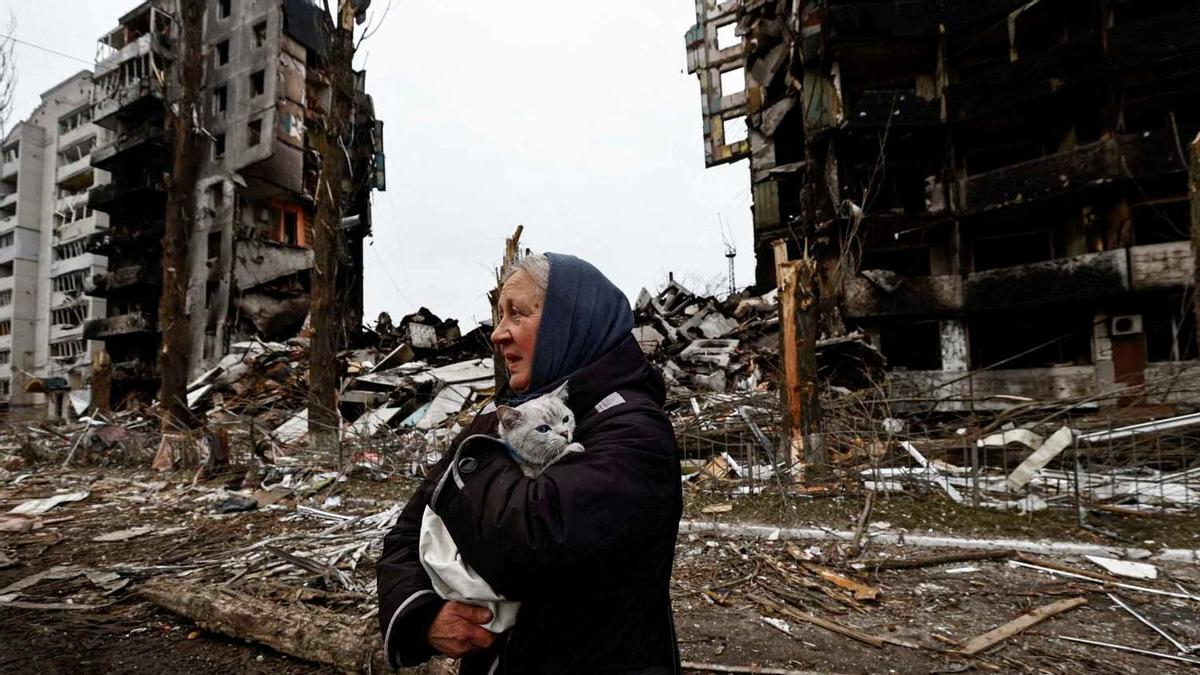 Una mujer lleva a su gato mientras pasa por delante de los edificios destruidos por los bombardeos rusos, en Borodyanka, en la región de Kiev, Ucrania, el 5 de abril de 2022.