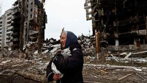 Una mujer lleva a su gato mientras pasa por delante de los edificios destruidos por los bombardeos rusos, en Borodyanka, en la región de Kiev, Ucrania, el 5 de abril de 2022.