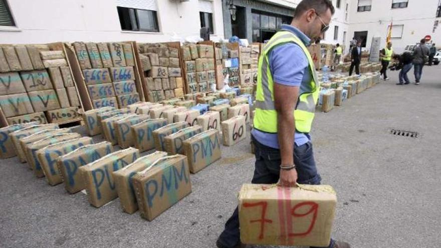 Un guardia civil acarrea uno de los fardos encontrados en el camión. / a. carrasco ragel