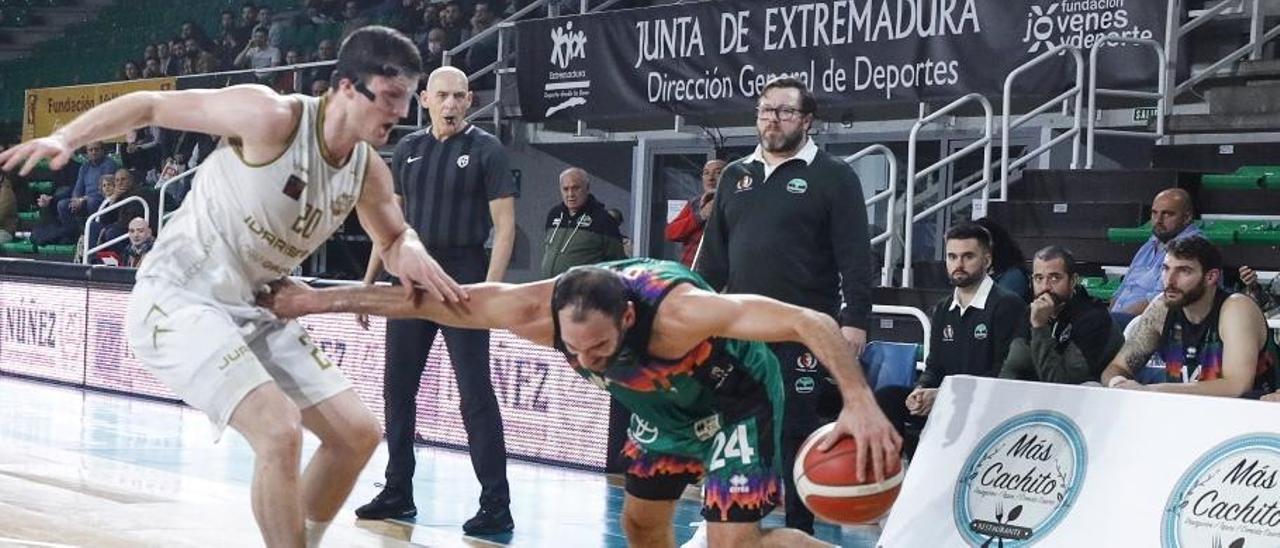 Dani Rodríguez intenta marcharse de un rival durante el partido ante el Juaristi, con Roberto Blanco y el banquillo detrás.