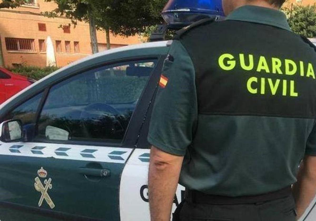 10/12/2024 Imagen de archivo de un agente de la Guardia Civil ante un coche patrulla SOCIEDAD GUARDIA CIVIL