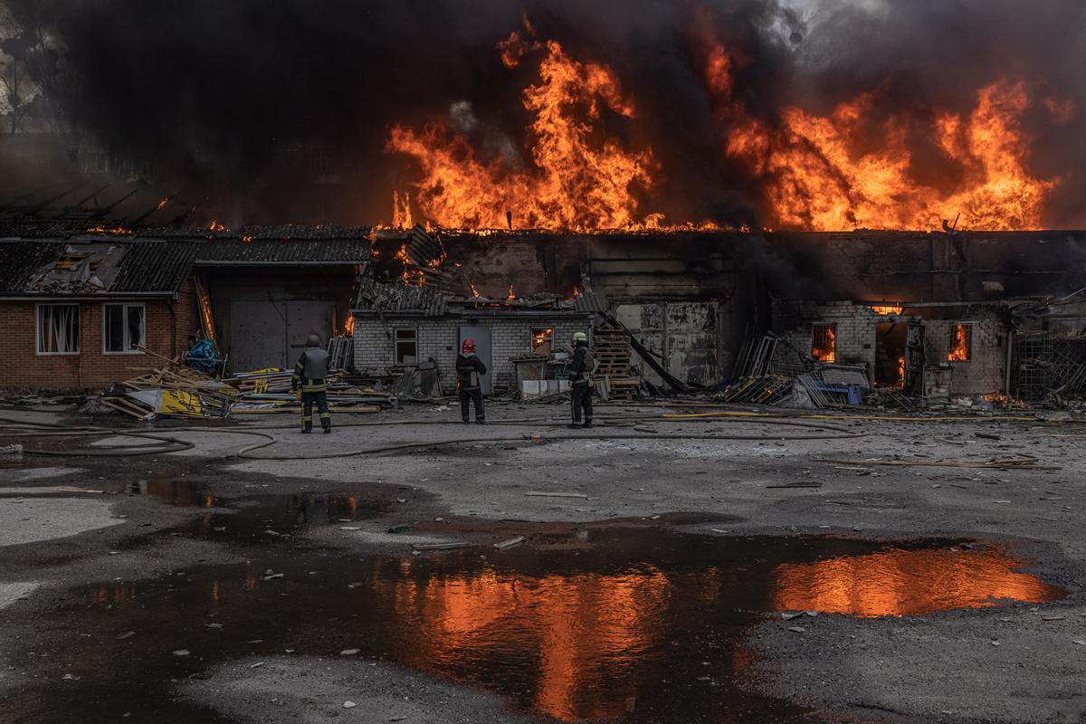 Los bomberos extinguen el fuego en un almacén que fue alcanzado por el bombardeo de la artillería rusa, en Kharkiv, noreste de Ucrania, el 28 de marzo de 2022. Kharkiv, la segunda ciudad más grande de Ucrania de 1,5 millones de habitantes, que se encuentra a unas 25 millas de la frontera rusa, ha sido fuertemente bombardeada por las fuerzas rusas en las últimas semanas, con muchos civiles muertos en la ciudad.
