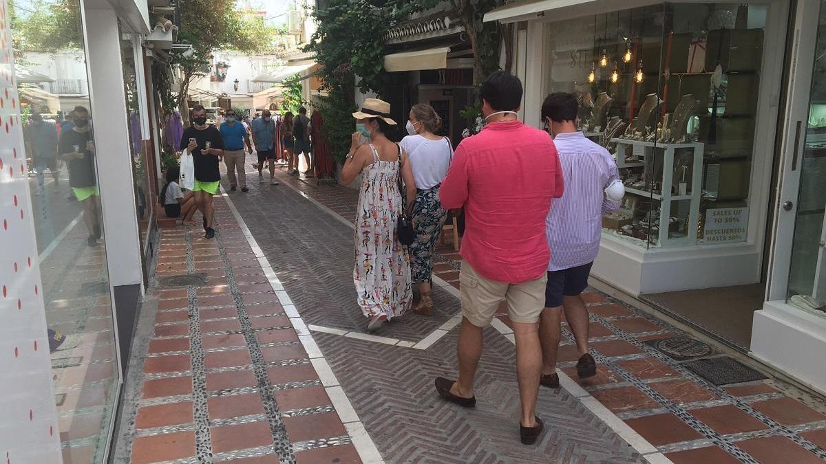 Turistas paseando por el centro de Marbella con mascarilla.