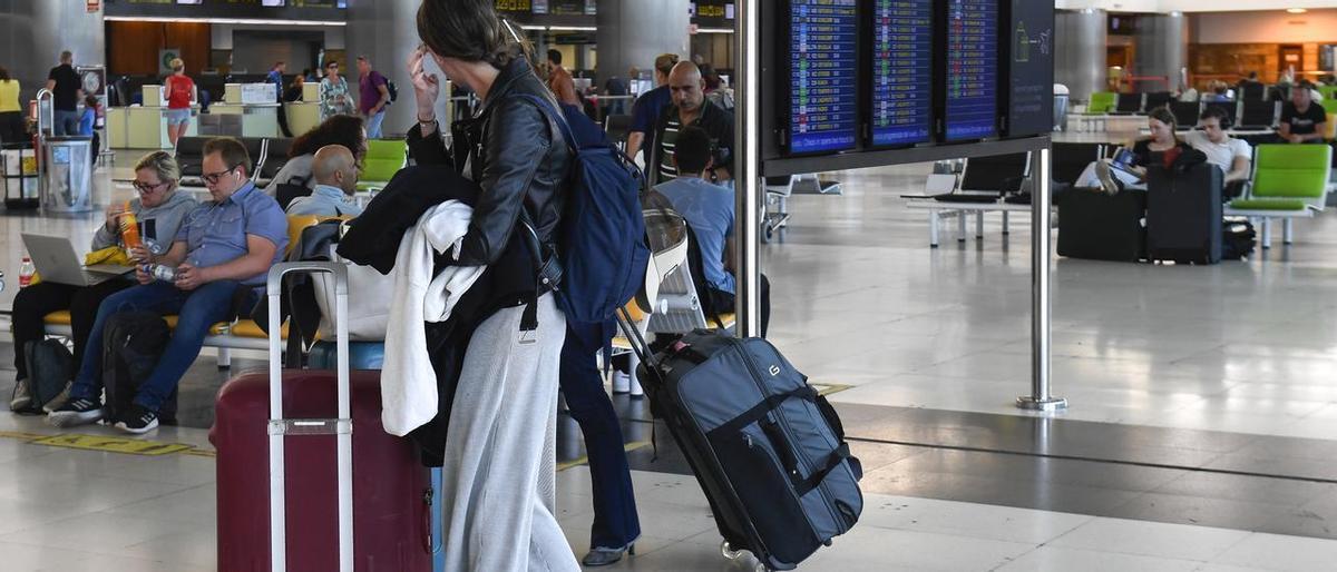 Una pasajera en el aeropuerto junto a sus maletas.