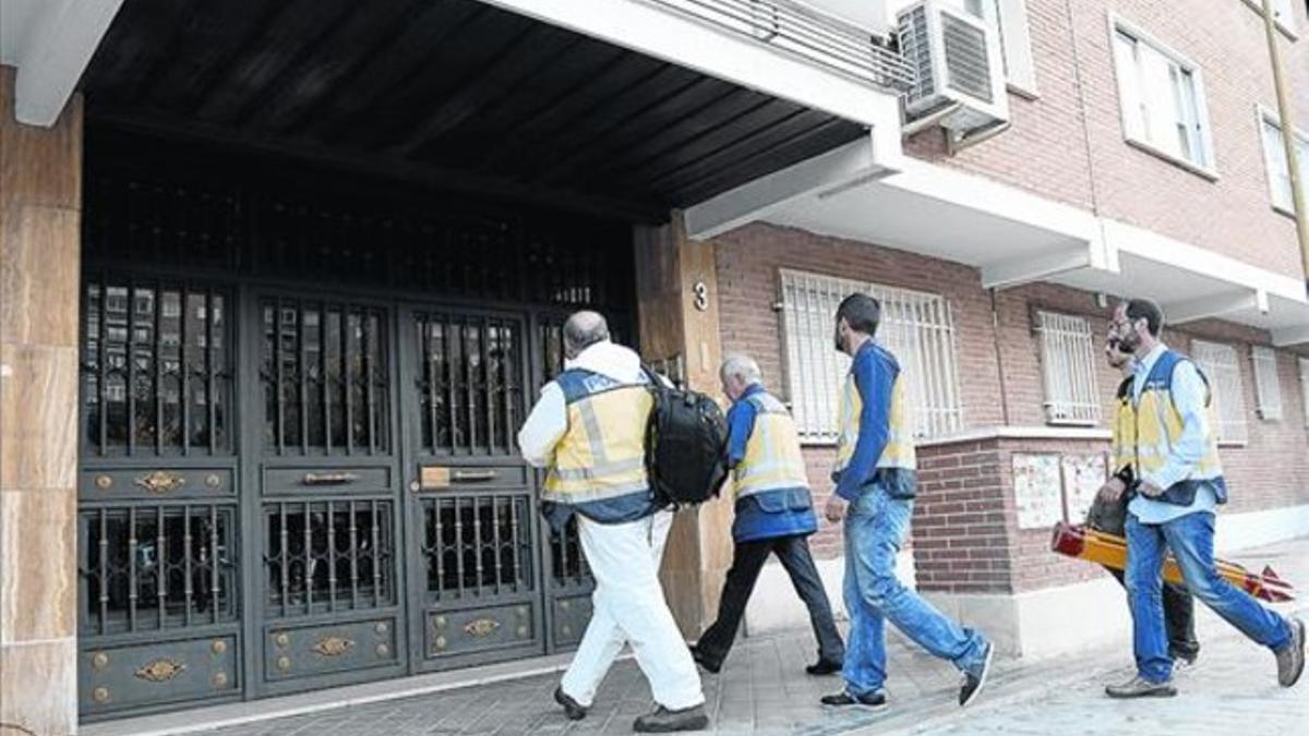 Agentes de la policía científica entran en el número 3 de la calle de Santa Virgilia de Madrid, ayer.