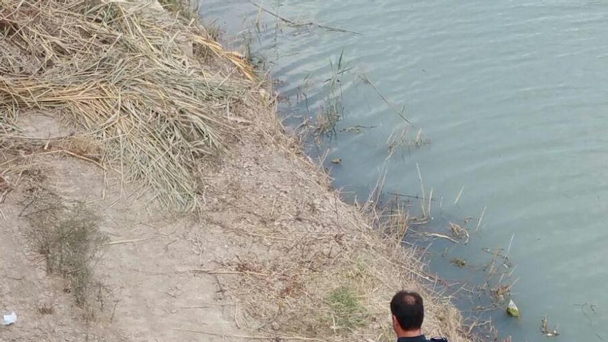 Policía Local y servicios de emergencias atendiendo a la joven en el río