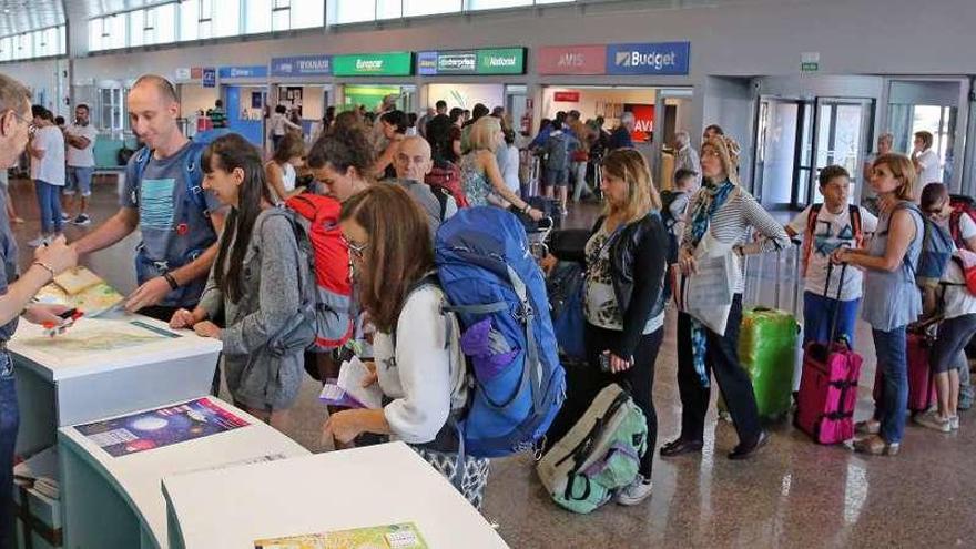 Viajeros en la oficina de turismo de Peinador durante el pasado verano. // Marta G. Brea