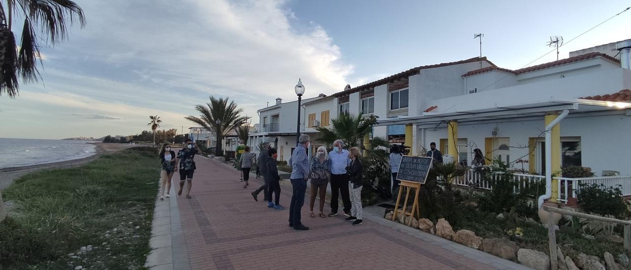 Un grupo de vecinos charla con la alcaldesa de Cabanes delante de las casetas amenazadas por el derribo, en el poblado de Torre la Sal.