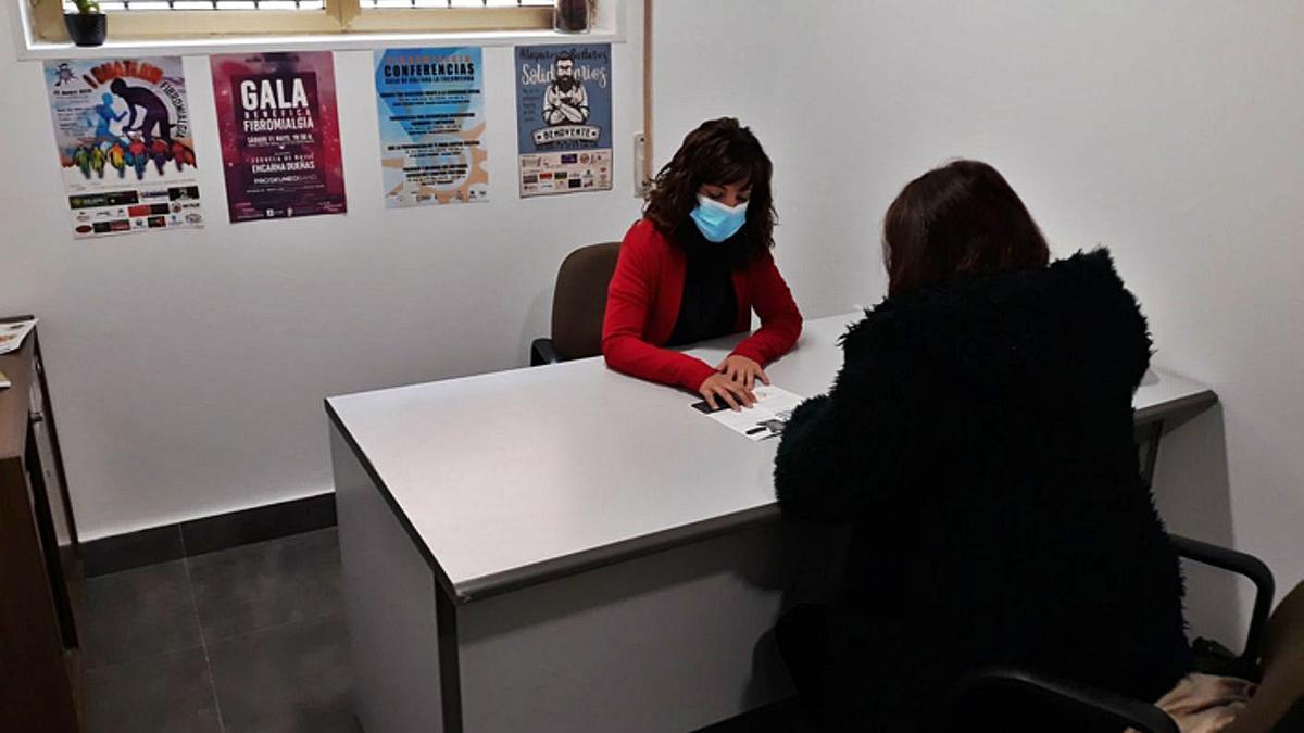 Ruth Colinas, de frente, atiende a una socia en la sede de Lagares. | E. P.