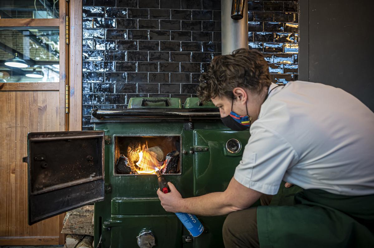 Buster Turner, ante la cocina económica en la que arde la madera.