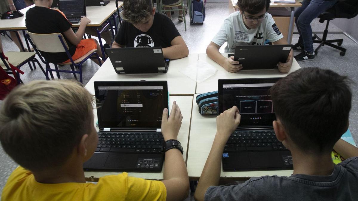 Varios alumnos utilizan ordenadores portátiles en una actividad en el aula en Valencia.