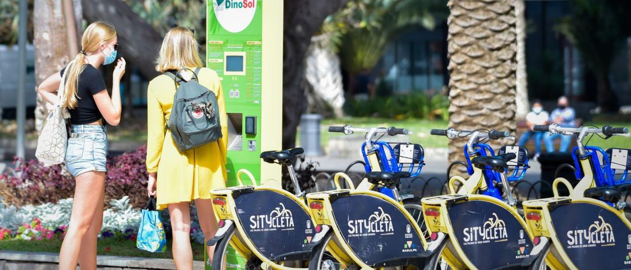 Dos turistas se interesan por el sistema de alquiler de bicicletas de Las Palmas de Gran Canaria. | |