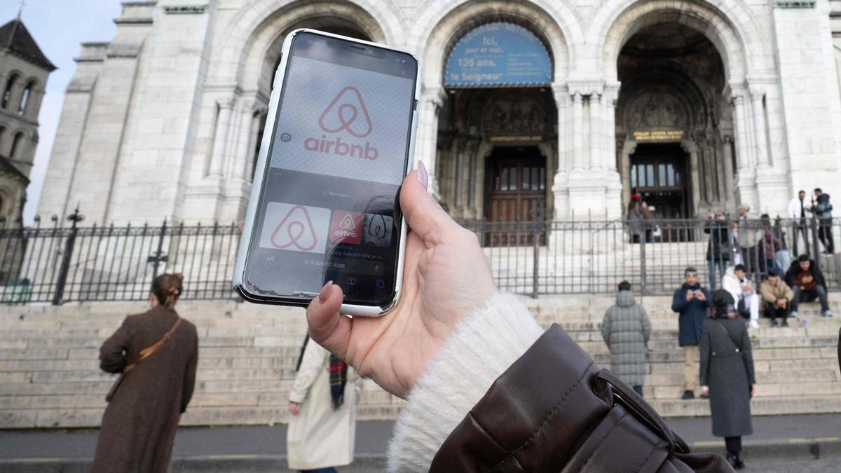 Una persona sostiene un teléfono con la aplicación de Airbnb abierta.