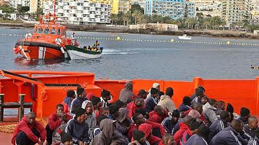 Algunos de los 121 inmigrantes irregulares que viajaban a bordo de los dos cayucos  que llegaron ayer al muelle tinerfeño de Los Cristianos tras ser rescatados por Salvamento Marítimo.