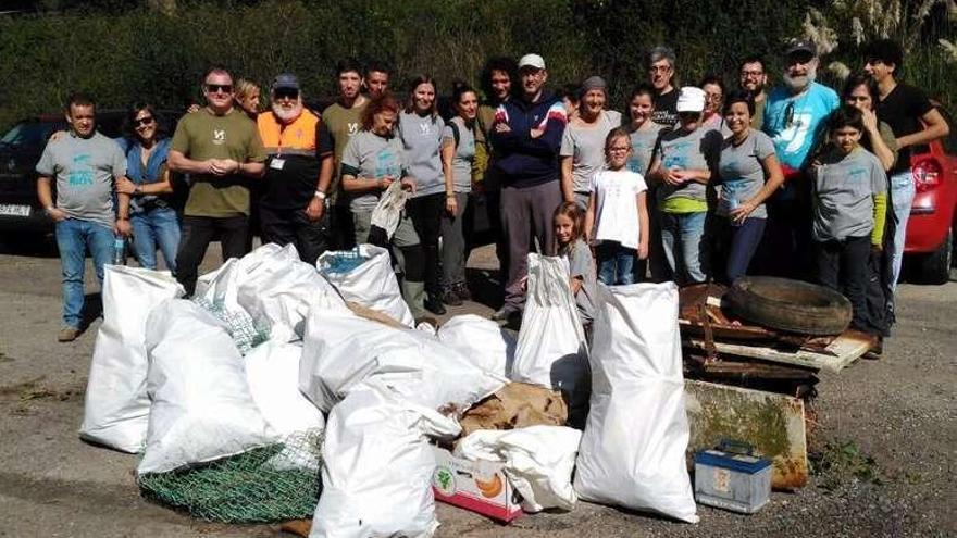 Voluntarios posan con los desperdicios retirados del entorno del Mero.