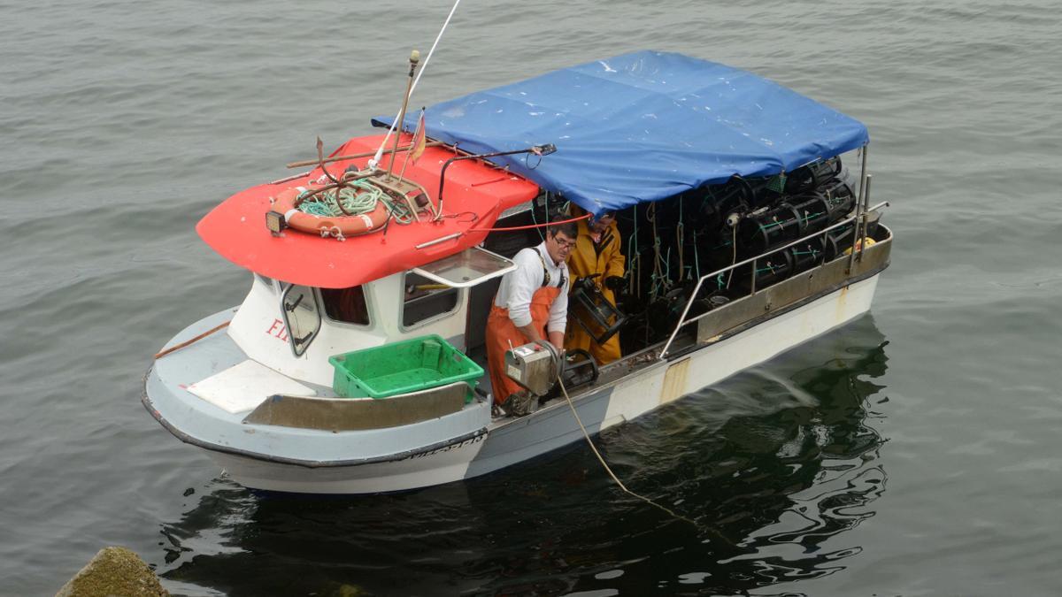 Un barco repleto de nasas de nécora y camarón en la ría.