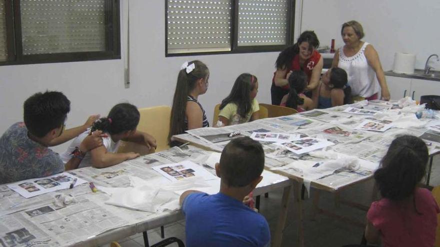 Los niños siguen con atención las explicaciones de las dos personas que imparten el taller de maquillaje.