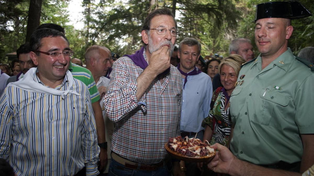 Rajoy prueba una tapa de pulpo acompañado por el alcalde de O Cabralliño