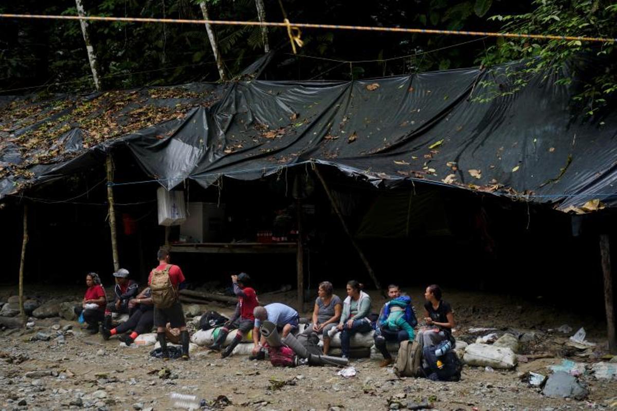 Migrantes cruzan el río Muerto en el Tapón del Darién, de viaje hacia los Estados Unidos, en Acandi, Colombia