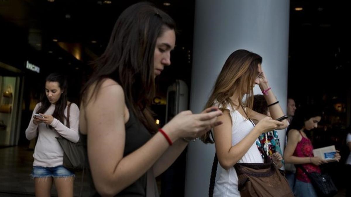 Dos chicas usan sus teléfonos