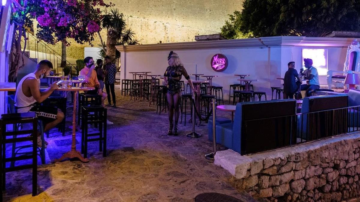 GRAF3373  IBIZA  19 08 2020 - Varias personas apuran los minutos antes del cierre de un bar en Ibiza  este miercoles  Las medidas para luchar contra el coronavirus acordadas entre el Gobierno y las comunidades han entrado en vigor en Baleares  entre otras medidas  la hosteleria y restauracion debe garantizar la distancia interpersonal minima de 1 5 metros en servicios de barras  la distancia entre mesas y una limitacion de 10 personas por mesa  con un horario de cierre a la 1 de la madrugada  con la imposibilidad de aceptar nuevos clientes a partir de las doce de la noche  EFE  Sergio G  Canizares