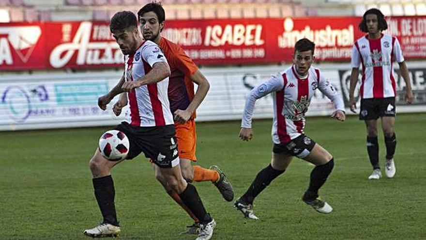 Juanan, con el balón, junto a David López y Fer.