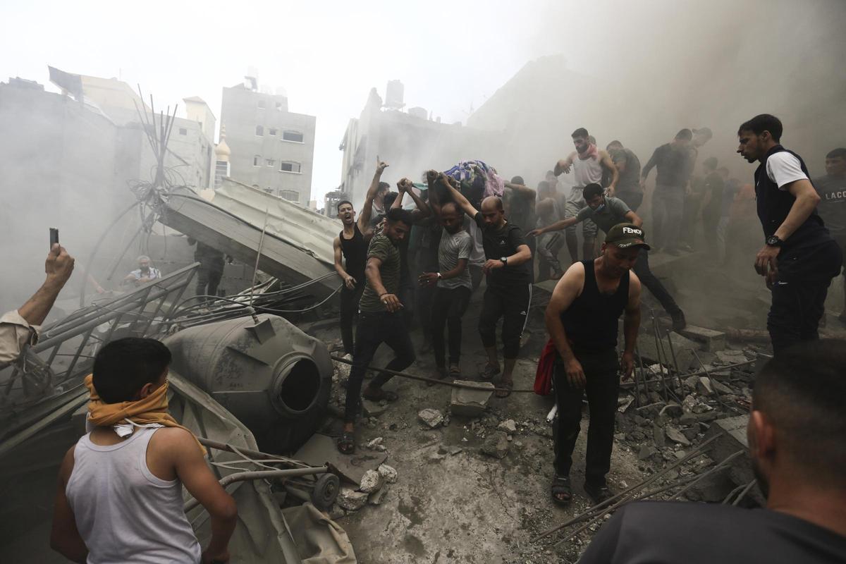 Palestinos recuperan cadáveres de entre los escombros de un edificio tras un ataque aéreo de Israel en el campo de refugiados de Jebaliya, en la Franja de Gaza.