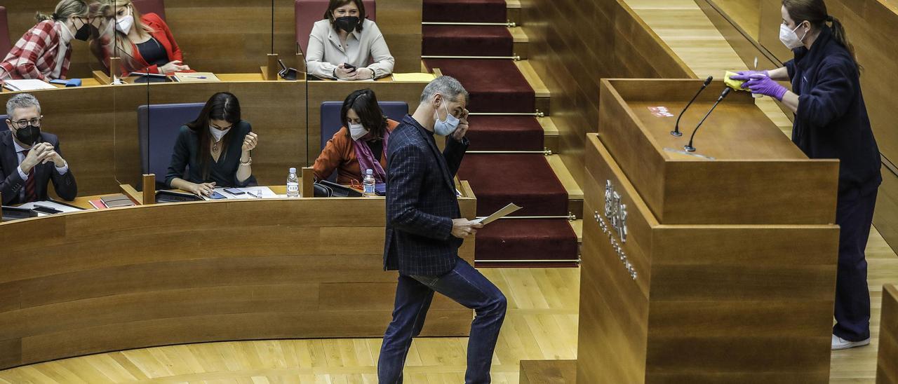 El líder de Ciudadanos, Toni Cantó, espera a que una ujier limpie la tribuna para iniciar su intervención esta mañana