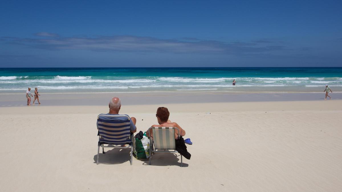 Dos turistas descansan en una playa de Corralejo.
