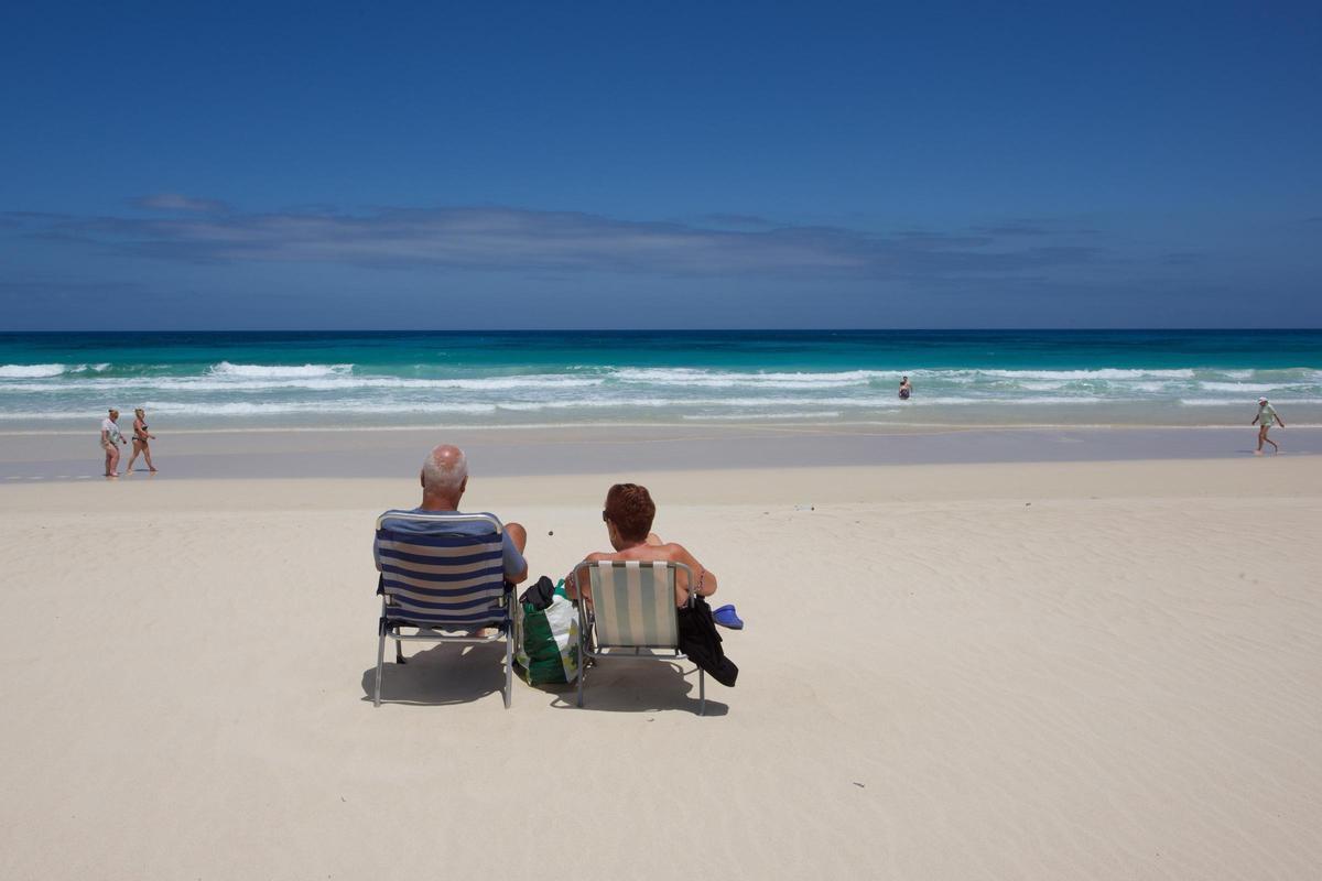 Dos turistas descansan en una playa de Corralejo.