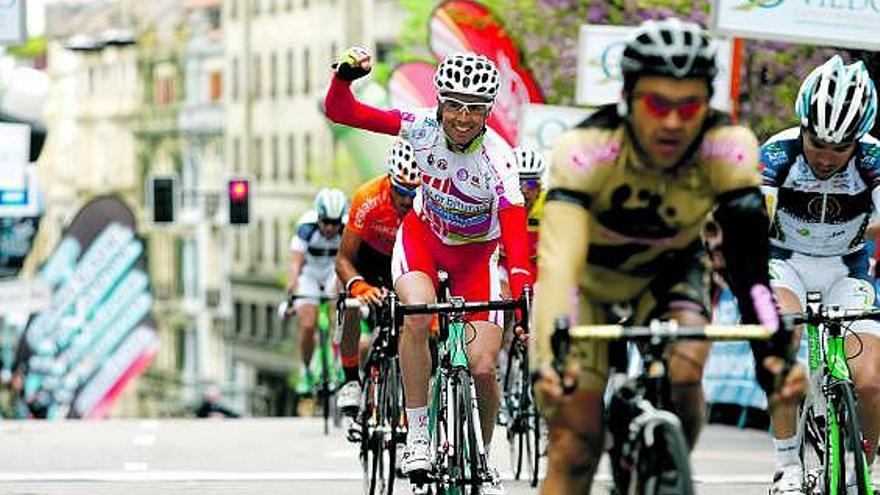 Santi Pérez levanta el brazo al cruzar la meta en señal de alegría por el triunfo en la Vuelta de su compañero Zaballa.