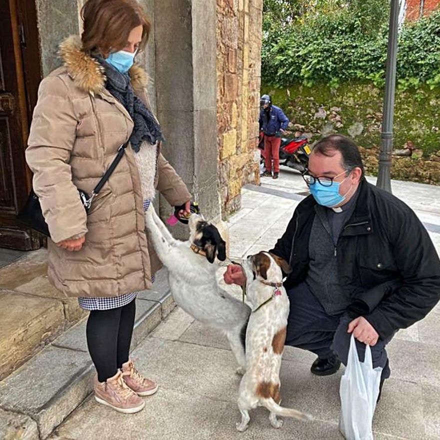 El sacerdote David Cuenca saluda a las mascotas de Luz Padilla, "Pepa" y "Lola".