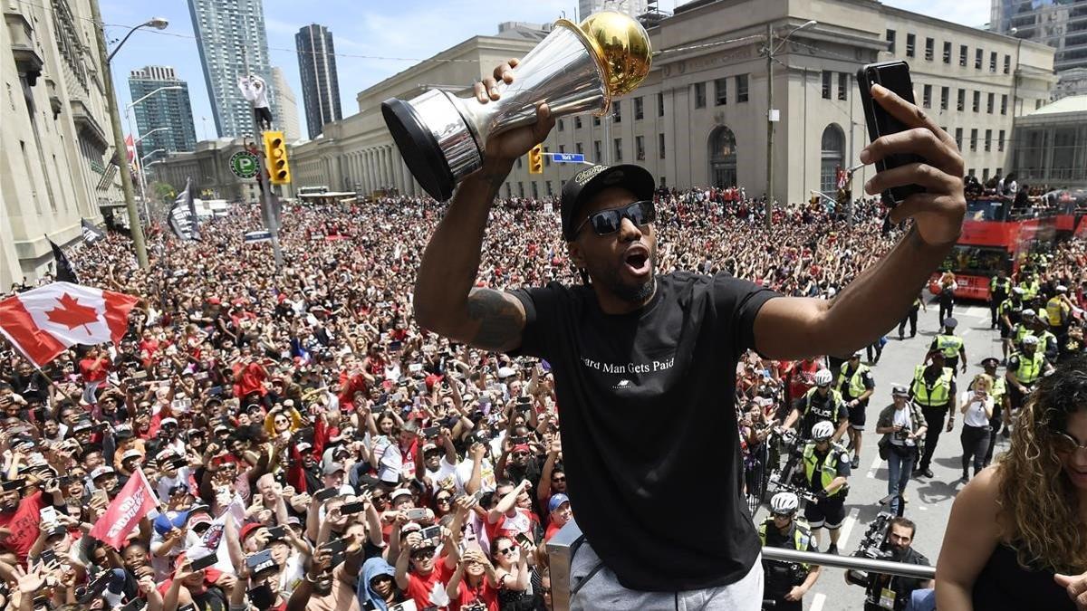 Kawhi Leonard se hace un selfie con el trofeo de campeón de la NBA.