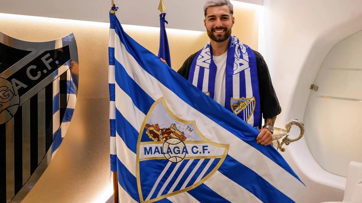 Álex Pastor posa junto a la bandera del Málaga CF.