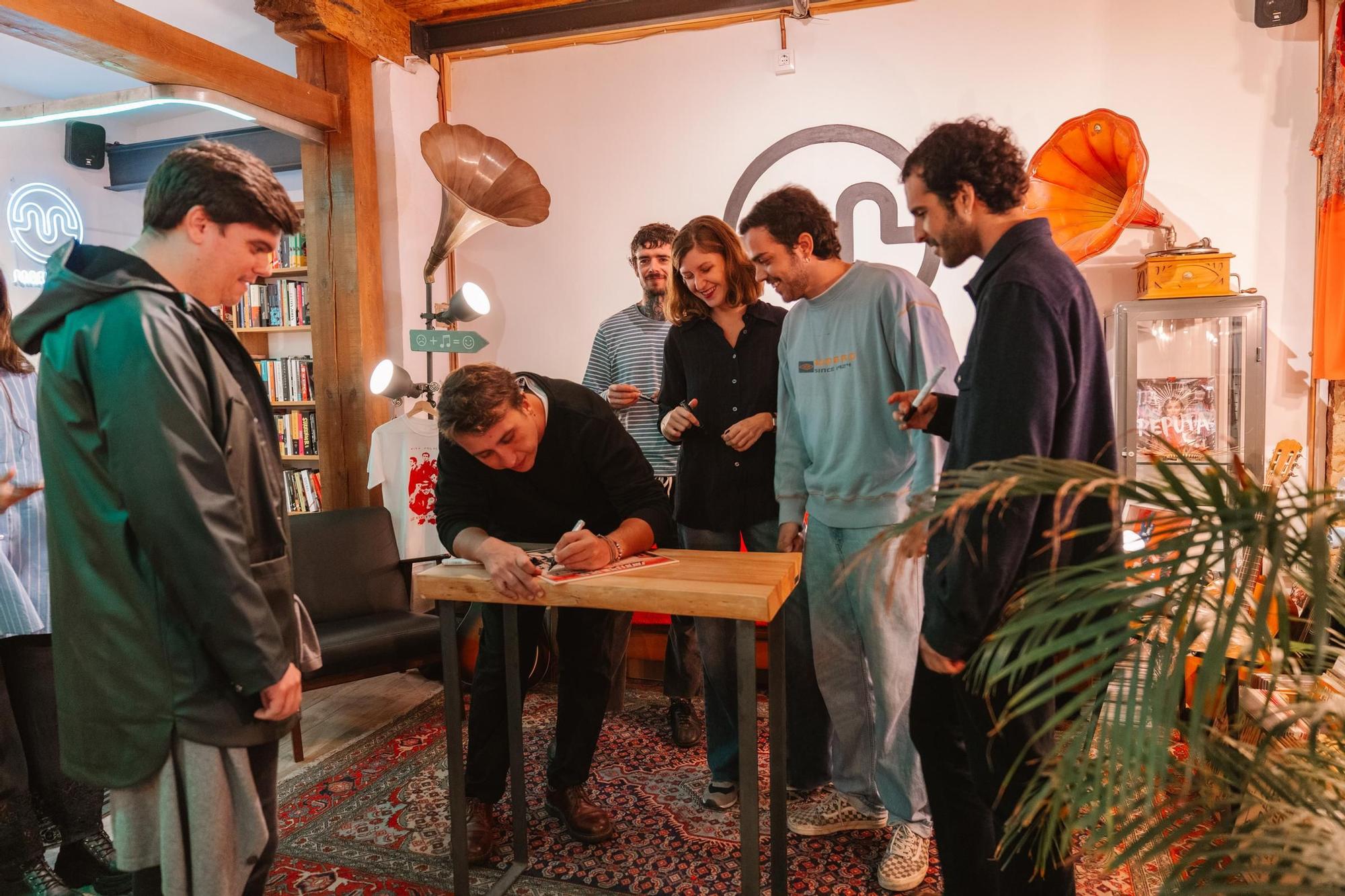 Los miembros de Niña Polaca firman ejemplares de su último álbum en la tienda de discos Marilians.