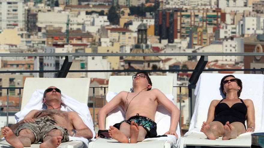 Turistas disfrutan del sol en la terraza superior de un hotel de Málaga.